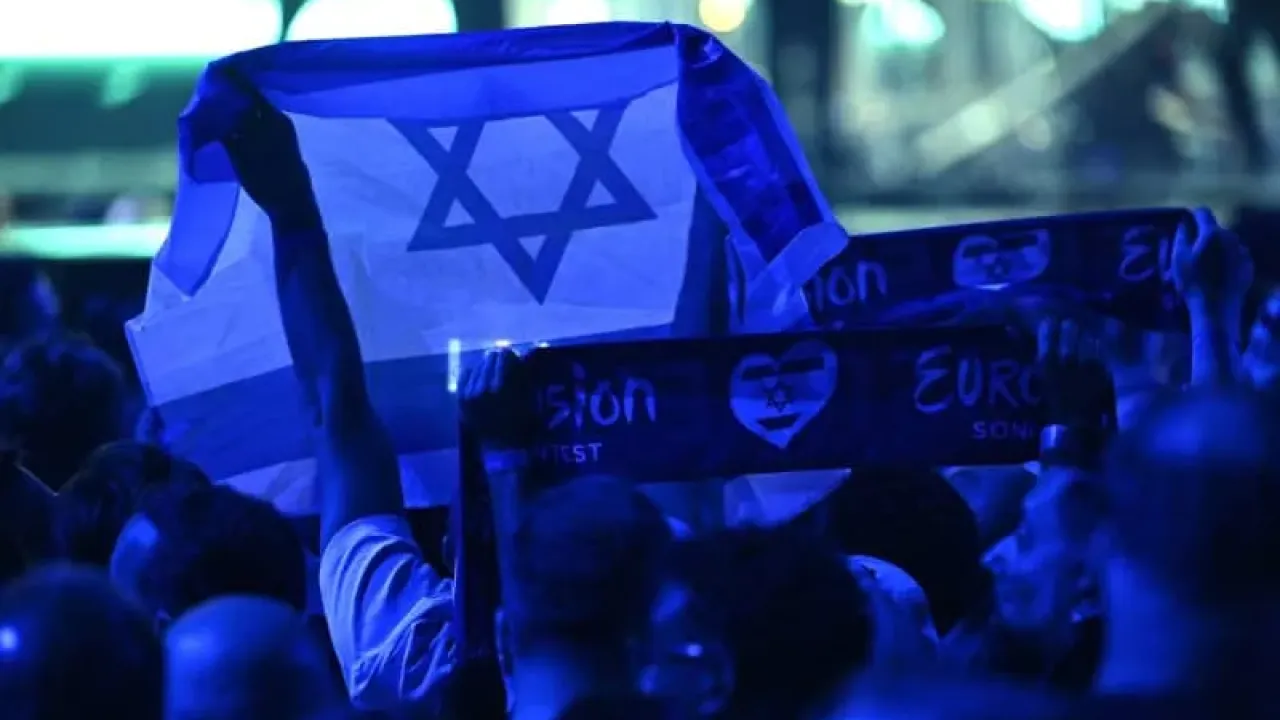 A person holds an Israeli flag during the Grand Final of the Eurovision Song Contest 2025 in Basel. The European Broadcasting Union (EBU), which organizes Eurovision, said on Thursday that it will hold an online meeting in November to vote on participation in the 2026 contest, as debate over Israel&#39;s involvement continues to stir controversy. Heikki Saukkomaa/Lehtikuva/dpa