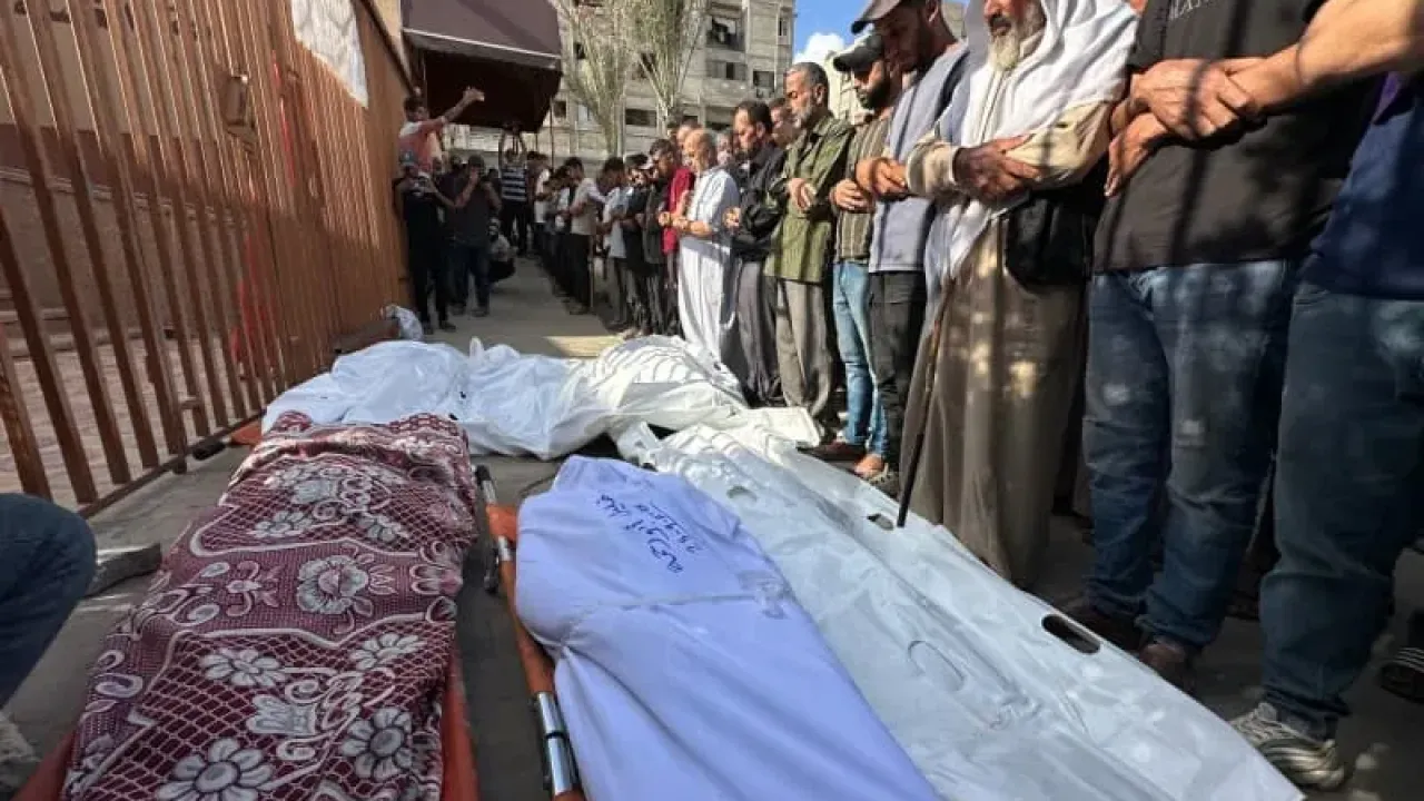Palestinians pray near the bodies of those lost their lives after Israeli attacks on different areas in Gaza. Mohammed Salama/APA Images via ZUMA Press Wire/dpa
