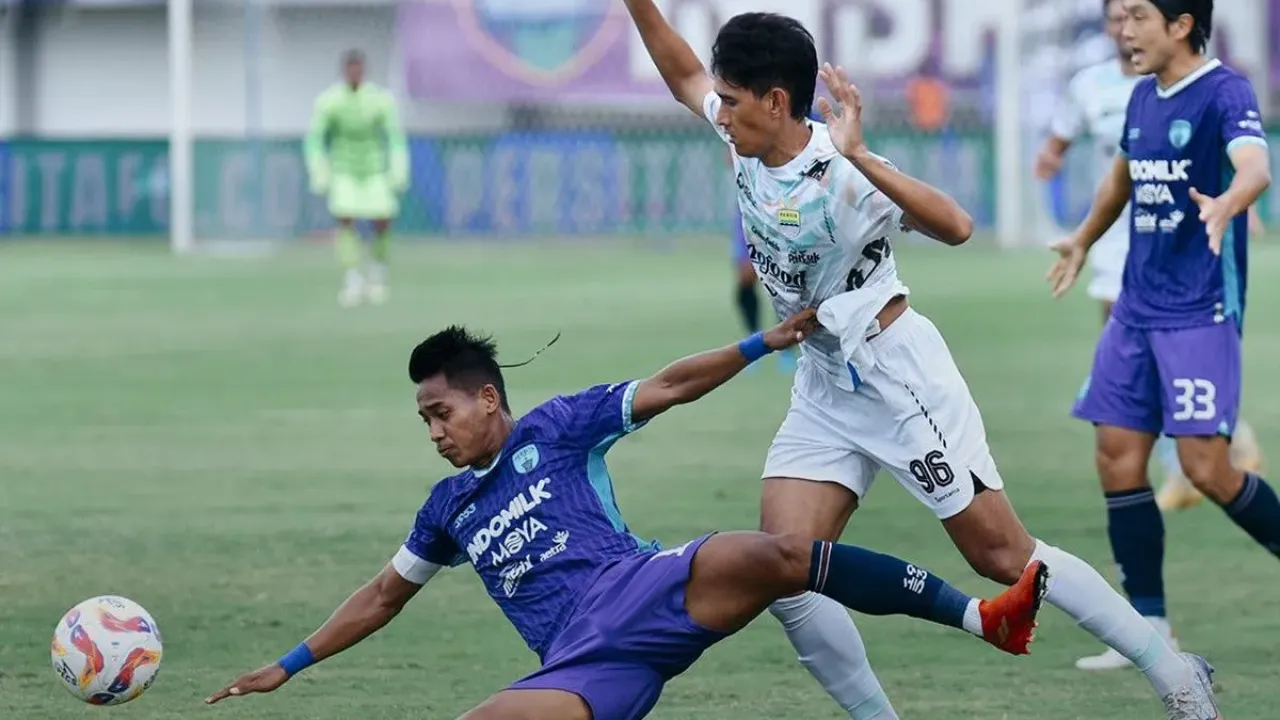 Aksi penyerang sayap Persib Ryan Kurnia (putih) dalam upaya melewati bek Persita Tangerang M Toha dalam laga pekan ke-33 Liga 1 2024-2025, Jumat (16/5/2025) di Indomilk Arena.