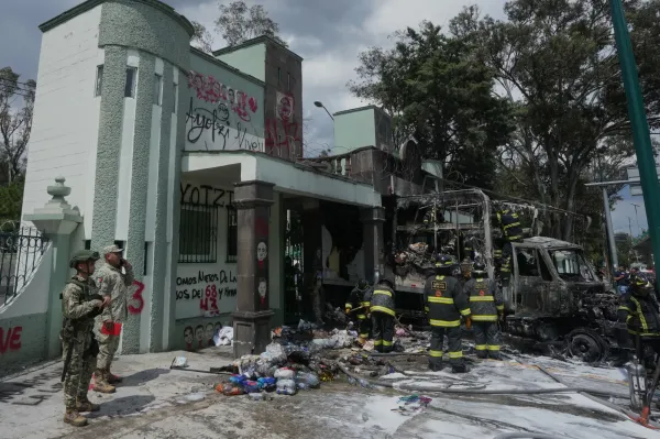 Soldiers and firefighters work the scene after demonstrators lit a garbage truck on fire during a protest marking the 11-year anniversary of the disappearance of 43 students from an Ayotzinapa rural teacher's college, outside the entrance of Campo Militar, in Mexico City, Thursday, Sept. 25, 2025. (AP Photo/Fernando Llano)ASSOCIATED PRESS
