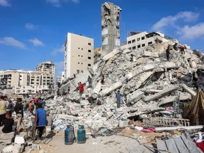Orang-orang mencari barang-barang yang dapat diselamatkan di tumpukan puing di lokasi runtuhnya Menara Sussi, yang dihancurkan oleh militer Israel, di Kota Gaza pada Sabtu (6/9/2025).