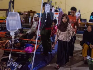 Pasien korban keracunan massal berjalan dengan infus terpasang saat mendapatkan perawatan di Posko Penanganan Kantor Kecamatan Cipongkor, Kabupaten Bandung Barat, Jawa Barat, Jumat (26/9/2025). Sebanyak 17 orang korban kembali mendapatkan perawatan setelah sempat dinyatakan pulih pascakeracunan massal usai mengonsumsi makan bergizi gratis (MBG) pada Senin (22/9) dan Rabu (24/9) lalu. 