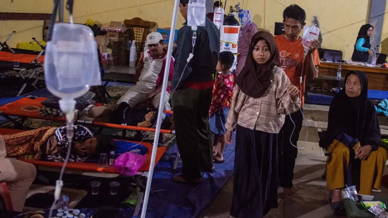 Pasien korban keracunan massal berjalan dengan infus terpasang saat mendapatkan perawatan di Posko Penanganan Kantor Kecamatan Cipongkor, Kabupaten Bandung Barat, Jawa Barat, Jumat (26/9/2025). Sebanyak 17 orang korban kembali mendapatkan perawatan setelah sempat dinyatakan pulih pascakeracunan massal usai mengonsumsi makan bergizi gratis (MBG) pada Senin (22/9) dan Rabu (24/9) lalu. 