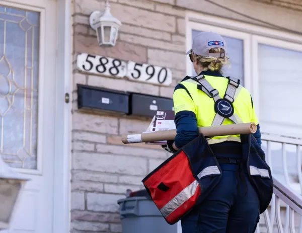 FILE - A Canada Post mail carrier delivers mail and packages on their route in Montreal, Wednesday, Nov. 13, 2024. (Christinne Muschi/The Canadian Press via AP, File)ASSOCIATED PRESS