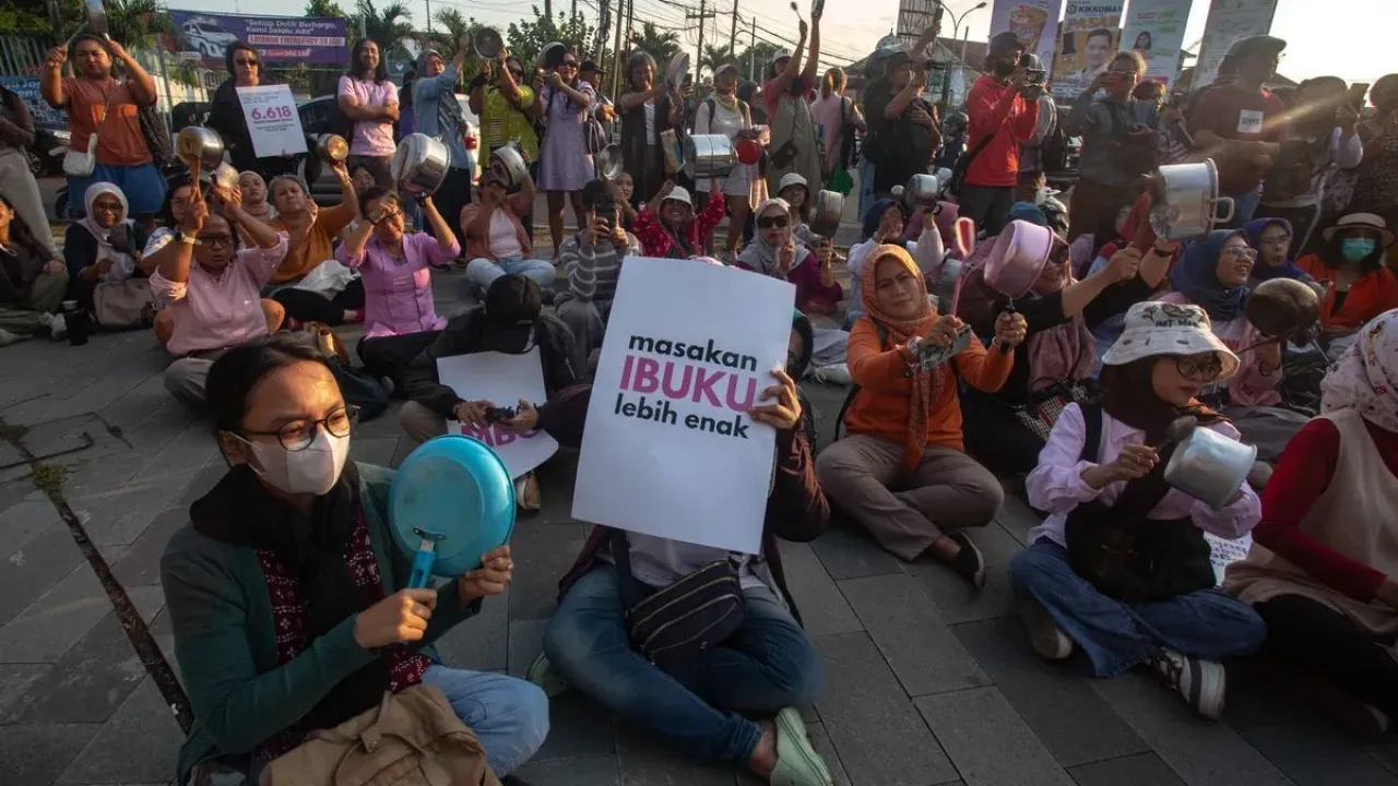 Sejumlah perempuan mengikuti aksi Kenduri Suara Ibu Indonesia dengan membentangkan poster dan memukul panci di Bundaran UGM, Sleman, D.I Yogyakarta, Jumat (26/9/2025). Aksi yang diikuti ibu-ibu dan perempuan muda tersebut sebagai bentuk sikap atas Kejadian Luar Biasa (KLB) keracunan Makanan Bergizi Gratis (MBG) di Bandung Barat dan berbagai wilayah lain di Indonesia.
