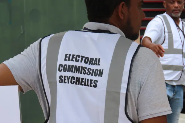 An electoral commission staff member directs voters toward the polling station at English River School in Victoria, Seychelles, Thursday, Sept. 25, 2025. (AP Photo/Emilie Chetty)ASSOCIATED PRESS