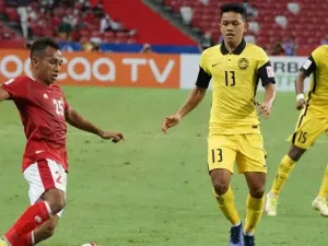 Pesepak bola Timnas Indonesia Irfan Jaya (kiri) berusaha melewati pesepak bola Timnas Malaysia Arif Aiman (tengah) dalam pertandingan grup B Piala AFF 2020 di National Stadium, Singapura, Minggu (19/12/2021). Indonesia menang dengan skor 4-1 dan lolos ke babak semifinal Piala AFF.