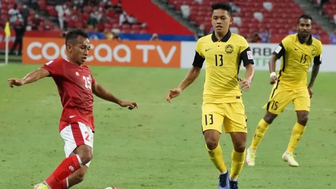 Pesepak bola Timnas Indonesia Irfan Jaya (kiri) berusaha melewati pesepak bola Timnas Malaysia Arif Aiman (tengah) dalam pertandingan grup B Piala AFF 2020 di National Stadium, Singapura, Minggu (19/12/2021). Indonesia menang dengan skor 4-1 dan lolos ke babak semifinal Piala AFF.