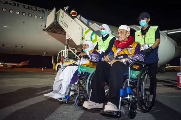 Petugas mendorong kursi roda dua orang haji dari kelompok terbang (kloter) pertama debarkasi Balikpapan setibanya di Bandara Internasional Sultan Aji Muhammad Sulaiman (SAMS) Sepinggan, Balikpapan, Kalimantan Timur, Selasa (17/6/2025) dini hari. Sebanyak 356 haji dan empat petugas haji asal Kota Balikpapan tiba di Bandara Internasional SAMS Sepinggan setelah menunaikan ibadah haji 2025 di Tanah Suci. 