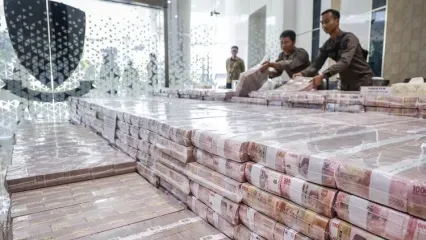 Petugas menata barang bukti berupa uang sitaan usai konferensi pers perkembangan penanganan perkara dugaan Tindak Pidana Pencucian Uang (TPPU) dan Tindak Pidana Korupsi (TPK) dalam kegiatan usaha perkebunan kelapa sawit PT Duta Palma Group di Gedung Bundar Jampidsus Kejaksaan Agung, Jakarta, Kamis (8/5/2025). Kejaksaan Agung menyita uang senilai Rp479 miliar dari dua anak perusahaan PT Darmex Plantations dalam perkara dugaan TPPU terkait perkara korupsi kegiatan usaha perkebunan kelapa sawit PT Duta Palma Group. 