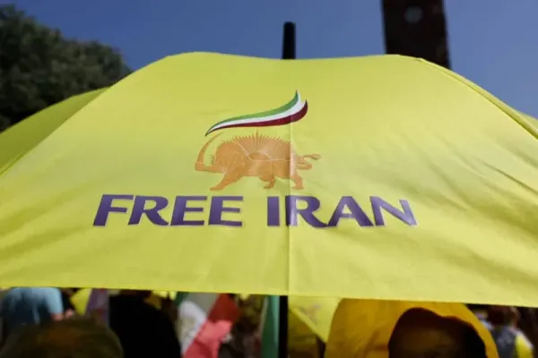 A person holds an umbrella with a sign that reads: "Free Iran" as supporters of the National Council of Resistance of Iran gather to protest against the Iranian regime, in Berlin, Germany, June 21, 2025. (photo credit: REUTERS/FABRIZIO BENSCH)