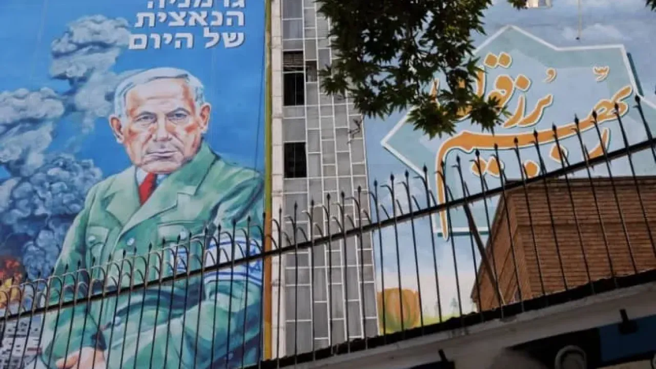 People walk past a billboard with a caricature of Israel's Prime Minister Benjamin Netanyahu, on a street in Tehran, Iran, August 10, 2025. (credit: Majid Asgaripour/West Asia News Agency/Reuters)