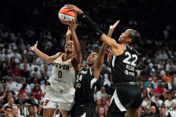 Sept. 21: The Indiana Fever's Kelsey Mitchell (0) attempts to score a layup while defended by the Las Vegas Aces' A'ja Wilson (22) and Jewell Loyd (24) during the second quarter of Game 1 at Michelob Ultra Arena.