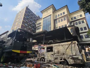 Warga mengamati kendaraan dinas kepolisian yang hangus terbakar di Mapolres Jakarta Timur, Jakarta, Sabtu (30/8/2025). Puluhan mobil dan sejumlah ruangan hangus terbakar akibat aksi unjuk rasa yang berlangsung ricuh. 