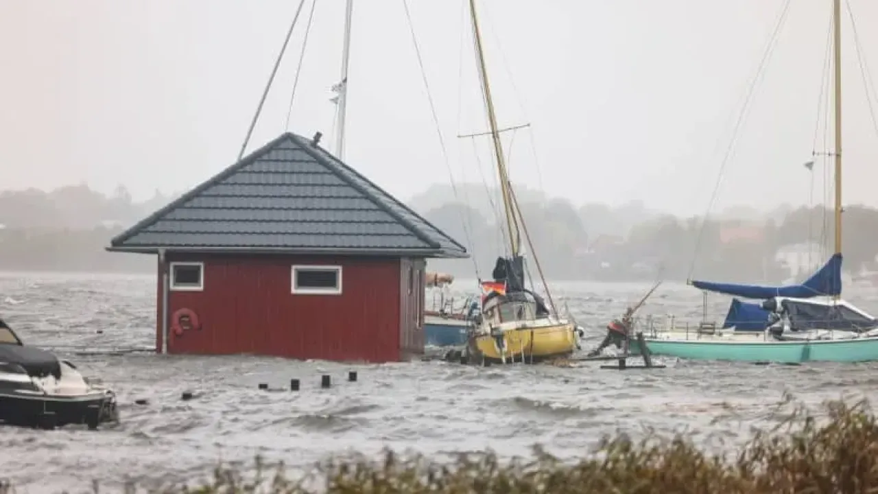 Water from the Schlei floods a boat harbor in Schleswig. Germany is under increasing threat from wildfires, heatwaves and floods as a result of global warming, climate experts warned on Wednesday. Frank Molter/dpa