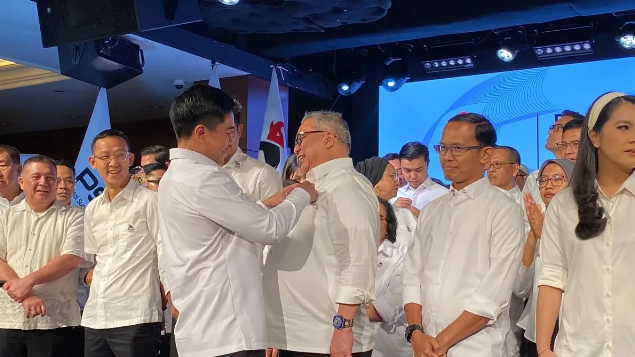 Ketua Umum PSI Kaesang Pangarep menyematkan pin gajah logo partai kepada Ketua Harian PSI Ahmad Ali di Djakarta Theater, Jakarta Pusat, Jumat (26/9/2025). 