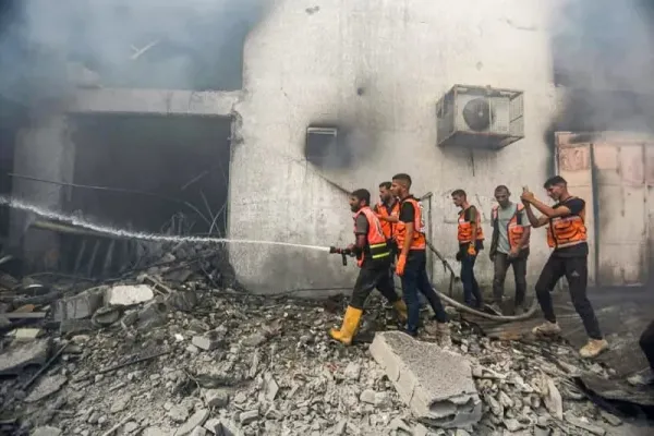 People are seen outside a building damaged in an Israeli air strike. Hasan Alzaanin/TASS via ZUMA Press/dpa