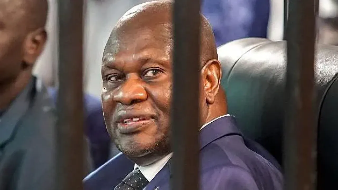 South Sudan&#39;s opposition leader and former vice-president Riek Machar (C) in navy blue suit, white shirt and a green dotted tie, sits in the dock during the third session of his trial at Freedom Hall in Juba on September 24, 2025.