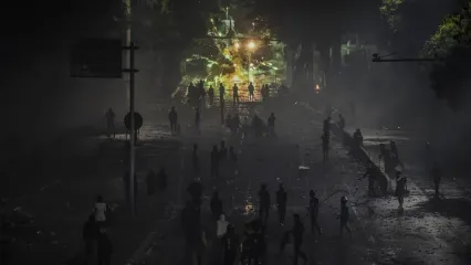 Pengunjuk rasa menembakan petasan ke anggota kepolisian saat aksi menuntut pengusutan kasus penabrakan pengemudi ojek daring oleh mobil rantis Brimob di depan Markas Komando Brimob Polda Metro Jaya, Kwitang, Jakarta, Jumat (29/8/2025). 