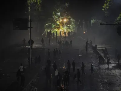 Pengunjuk rasa menembakan petasan ke anggota kepolisian saat aksi menuntut pengusutan kasus penabrakan pengemudi ojek daring oleh mobil rantis Brimob di depan Markas Komando Brimob Polda Metro Jaya, Kwitang, Jakarta, Jumat (29/8/2025). 