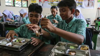 Seorang siswa berbagi lauk pauk kepada teman sebangkunya saat menyantap makanan program Makan Bergizi Gratis (MBG) di SMP Negeri 9 Kota Semarang, Jawa Tengah, Selasa (9/9/2025). Pemerintah Provinsi Jawa Tengah mencatat capaian realisasi penerima manfaat program MBG per tanggal 26 Agustus 2025 di provinsi itu sebanyak 2,7 juta orang penerima manfaat atau mencapai 28,14 persen dari total target sasaran yakni sebesar 9,6 juta orang penerima manfaat yang meliputi siswa sekolah, ibu hamil, ibu menyusui, dan balita. ANTARA FOTO/Makna Zaezar/foc.