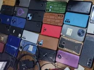 A close -up of different brands of phones and chargers placed on a table 