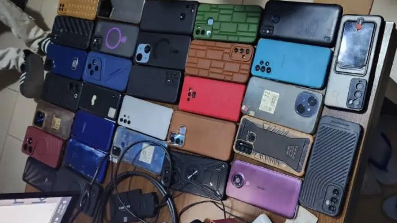 A close -up of different brands of phones and chargers placed on a table 