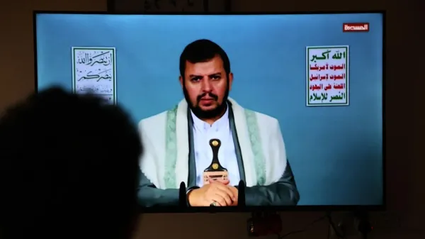 A man watches Houthi leader Abdul Malik al-Houthi speaking on television in Yemen (25 September 2025)
