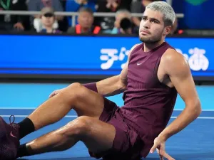 Carlos Alcaraz sits on the court after hurting his ankle 