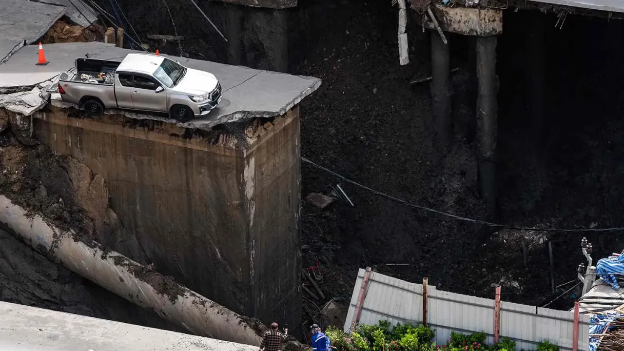 CHANAKARN LAOSARAKHAM/AFP via Getty The sinkhole in the ground after a road collapsed near a hospital in Bangkok on September 24, 2025