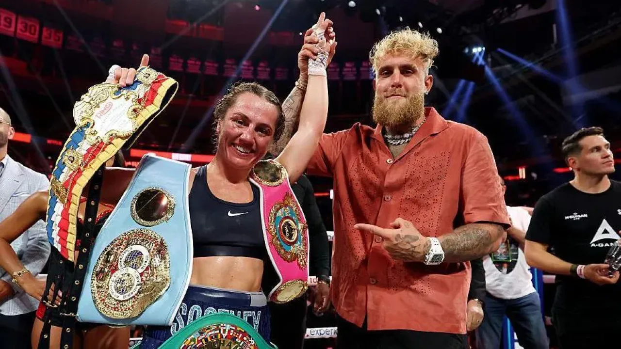 Ellie Scotney's hand is held up by Jake Paul 