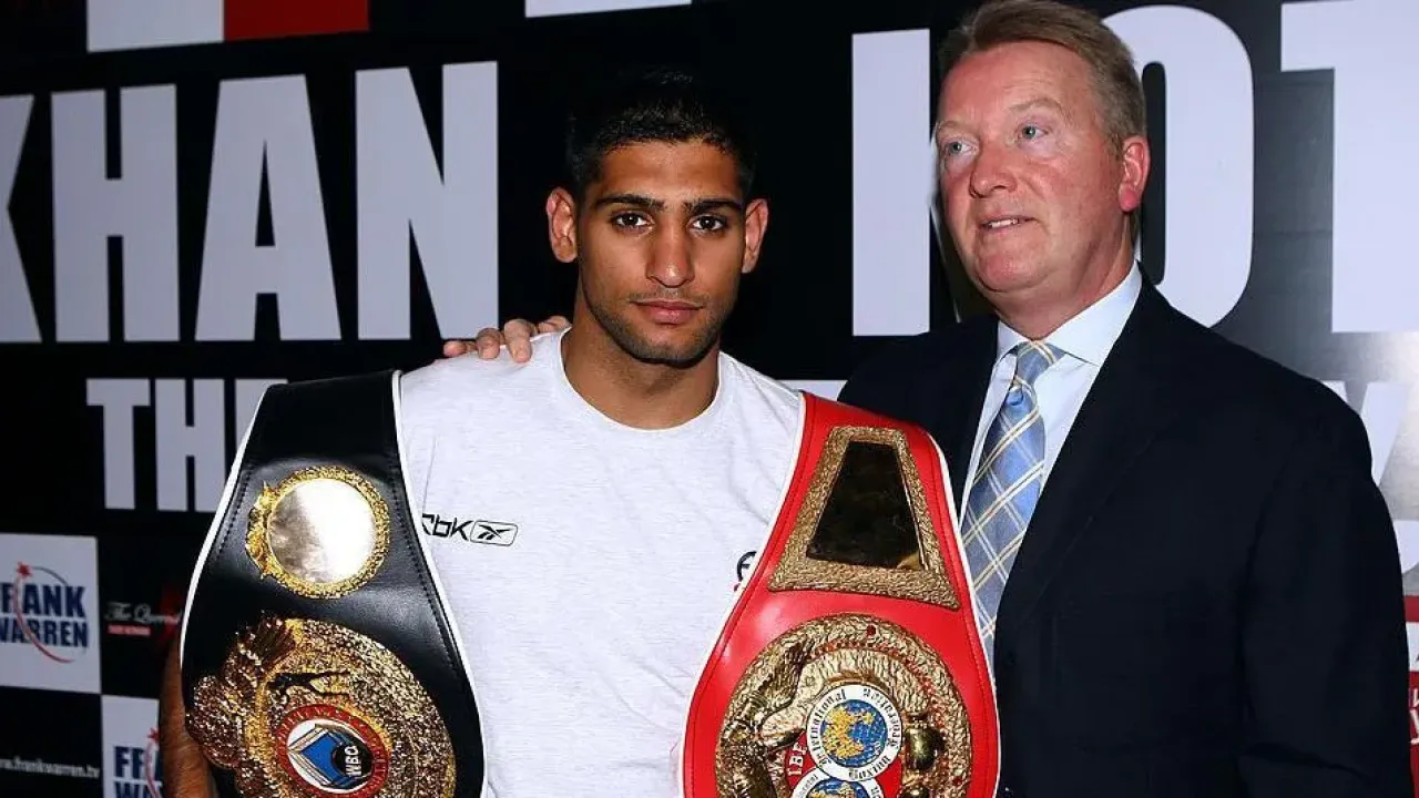 Frank Warren puts his arm around Amir Khan, who is holding his world titles