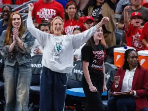 Indiana Fever guard Caitlin Clark and guard Sophie Cunningham on the sideline.