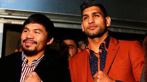Manny Pacquiao poses with his fist up beside Amir Khan