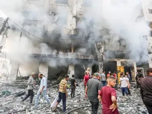 People are seen outside a building damaged in an Israeli air strike. Hasan Alzaanin/TASS via ZUMA Press/dpa