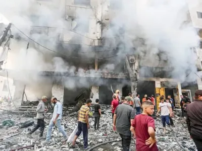 People are seen outside a building damaged in an Israeli air strike. Hasan Alzaanin/TASS via ZUMA Press/dpa