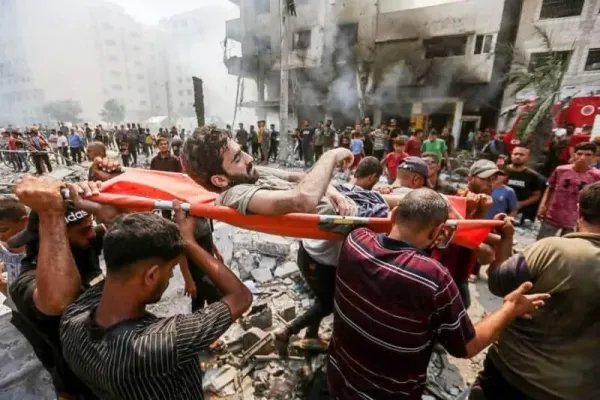 People carry a man injured in an Israeli air strike. Hasan Alzaanin/TASS via ZUMA Press/dpa