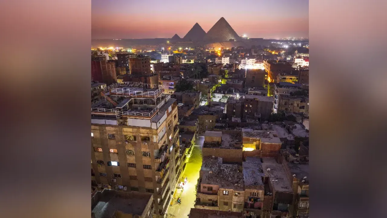 The stark contrast between the city of Cairo and the iconic Pyramids make for a stunning view during the blue hour, Cairo, Egypt, Africa