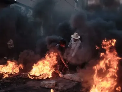 Protesters burning tires and placing large concrete blocks in the streets during a protest organized by the Gen Z movement to denounce water and power shortages and government mismanagement. Iako Randrianarivelo/ZUMA Press Wire/dpa