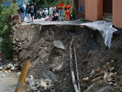 People look on as Kathmandu Metropolitan Police, with the assistance of local police, work to repair a road that collapsed due to heavy rainfall, damaging the section at Bafal. Skanda Gautam/SOPA Images via ZUMA Press Wire/dpa