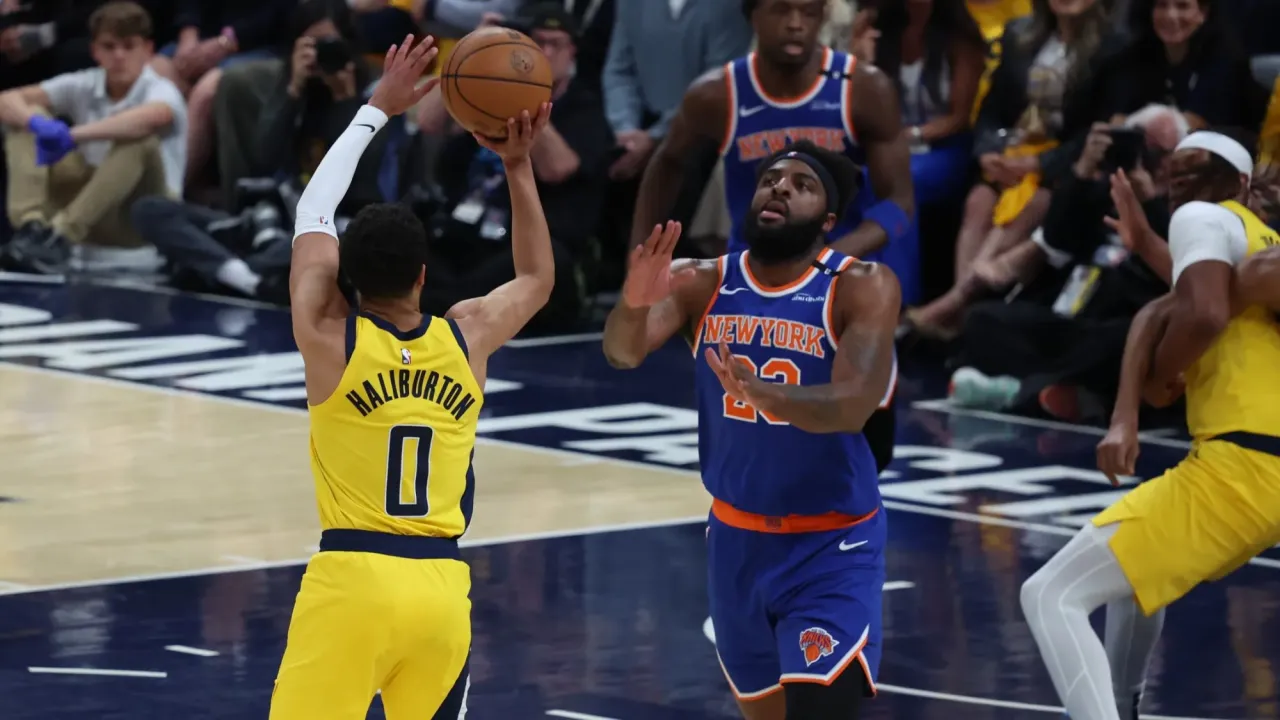May 27, 2025; Indianapolis, Indiana, USA; Indiana Pacers guard Tyrese Haliburton (0) shoots a three point basket over New York Knicks center Mitchell Robinson (23) during the first quarter of game four of the eastern conference finals for the 2025 NBA Playoffs at Gainbridge Fieldhouse. 