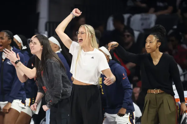 LAS VEGAS, NEVADA - SEPTEMBER 21: (L-R) Caitlin Clark #22 , Sophie Cunningham #8, and Assistant Coach Briann January of the Indiana Fever cheer after a basket against the Las Vegas Aces in the first quarter of Game One of the 2025 WNBA Playoffs semifinals.