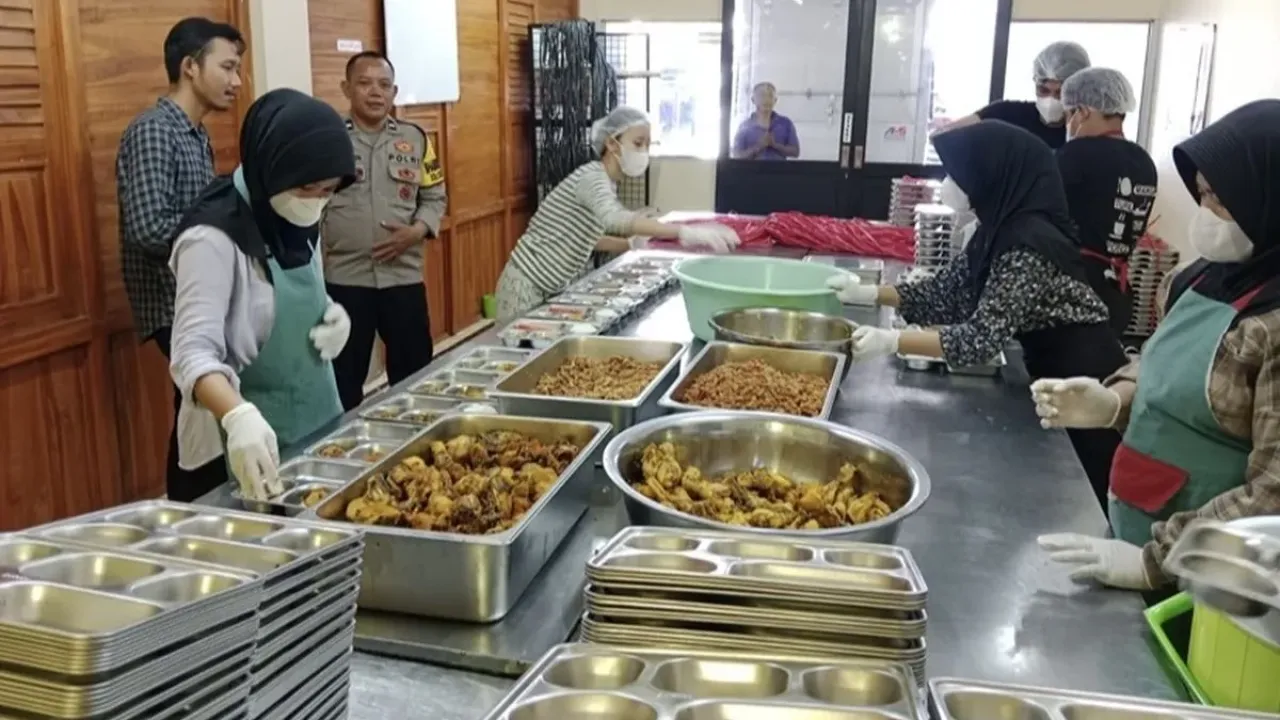 Polisi saat ikut memantau pelaksanaan pembuatan makanan MBG di Satuan Pelayanan Pemenuhan Gizi (SPPG) Yayasan Palma Palembayan Matur di Kelurahan Karanganyar, Indramayu, Selasa (30/9/2025)