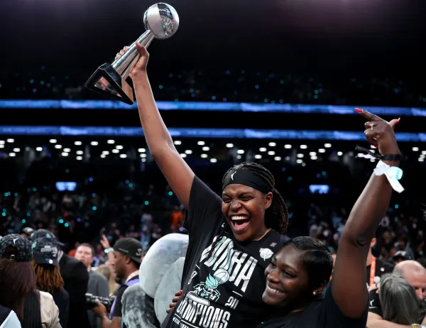 NEW YORK, NEW YORK - OCTOBER 20: Jonquel Jones #35 of the New York Liberty celebrates with her fiancee
 Nehsa and her MVP trophy after Game Five of the WNBA Finals against the Minnesota Lynx at Barclays Center on October 20, 2024 in the Brooklyn borough of New York City. The New York Liberty defeated the Minnesota Lynx 67-62 in overtime to win the championship. (Photo by Elsa/Getty Images)