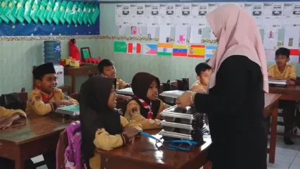 Guru di SDN Sendangsari, Kecamatan Bener, Purworejo, membagikan ompreng berisi menu makan siang gratis kepada siswa. Program Makan Bergizi Gratis (MBG) dinilai membuat anak-anak lebih bersemangat belajar sekaligus memastikan asupan gizi harian mereka terpenuhi