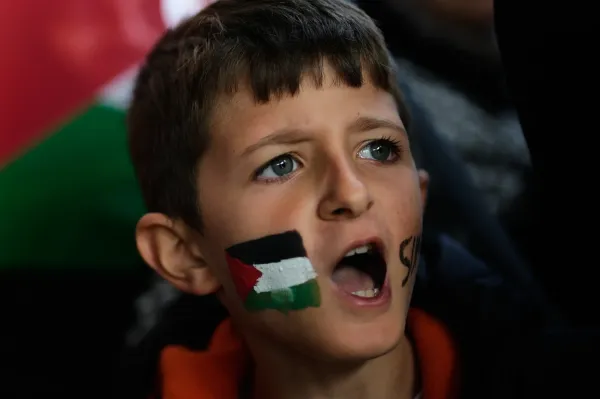 A boy with a Palestinian flag painted on his face chants slogans during a gathering outside Istanbul Airport, as people wait for the arrival of 137 activists from the Global Sumud Flotilla, in Istanbul, Turkey, Saturday, Oct. 4, 2025. (AP Photo/Khalil Hamra)(ASSOCIATED PRESS)