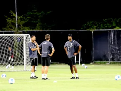 Pelatih Timnas Indonesia, Patrick Kluivert (kanan) berbincang dengan asistennya dalam sesi latihan di Lapangan C Kompleks Gelora Bung Tomo, Surabaya, Selasa (2/9/2025).