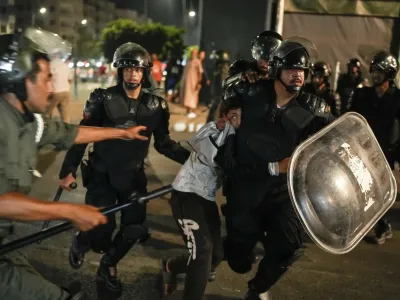 A boy is detained as youth led protests turned violent, in Sale, Morocco, Oct. 1, 2025 (AP photo by Mosa'ab Elshamy).