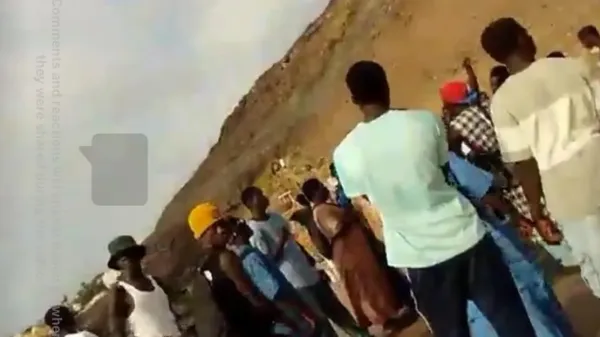 A still taken from James Nunan's Facebook Live broadcast. It shows people gathered on a beach.