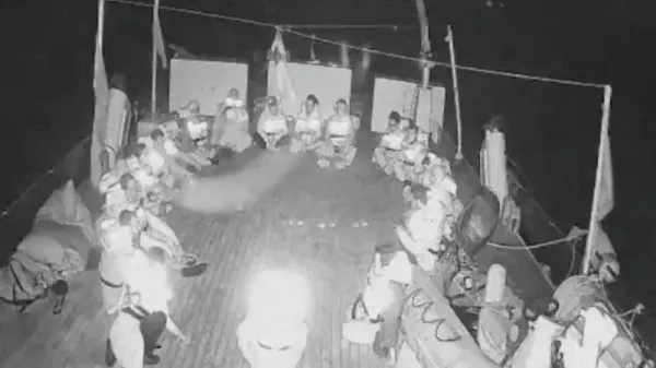 Black and white livestreamed footage shows crew members of the Alma vessel